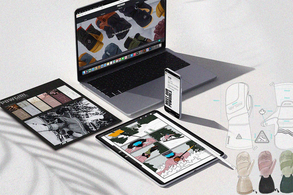 A styled flat-lay of a digital design mockup showing a laptop, smartphone, tablet, and a printed design board on a white textured surface. The screens and printed sheet display apparel design concepts, including gloves, in various colors and materials, alongside hand-drawn technical sketches.